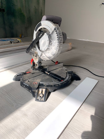 The miter saw or a multi material construction saw on the floor of the apartment