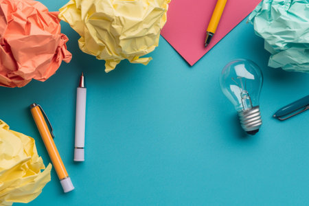 Creative ideas concept with crumpled paper and lightbulb on blue backgroundの素材
