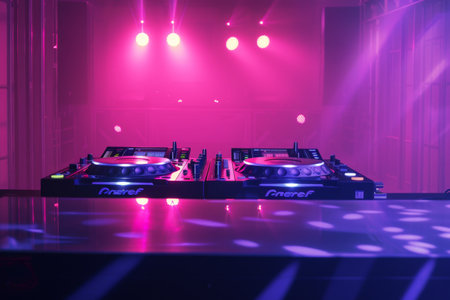 Two turntables sit atop a shiny table, reflecting the ambient light in a mesmerizing display of musical potential.の素材
