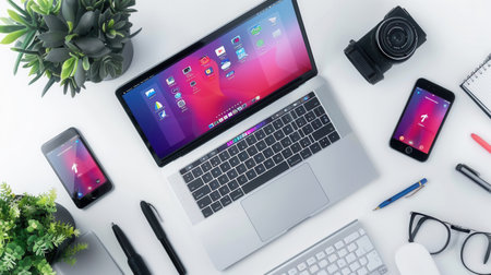 A modern laptop and tablet showcasing vibrant apps and work processes on their screens, sitting on a sleek desk. Perfect for IT companies and electronics manufacturers.の素材