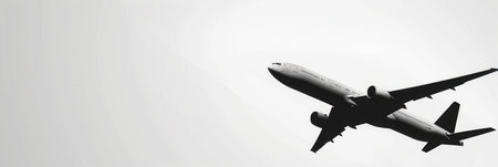 A minimal image of an airplane in flight against a white sky. The airplane is silhouetted, creating a sleek and modern look. Perfect for airlines and flight booking agencies.の素材