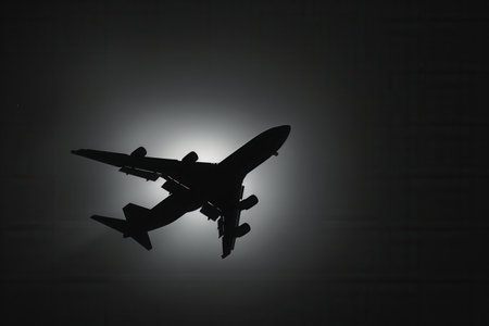 A minimalist image featuring a sleek silhouette of an airplane taking off against a bright, white sky. Perfect for airlines and travel agencies.の素材