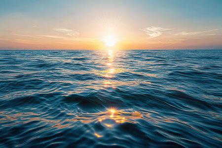 A peaceful ocean scene at sunset with warm colors reflected on the water.の素材