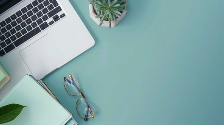 A contemporary workspace with a laptop, textbooks, and a plant, symbolizing modern methods of learning for online courses and educational platforms.の素材