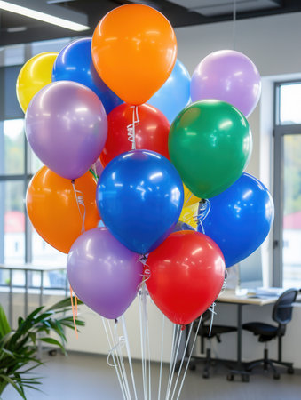 A bunch of colorful balloons in various hues decorate an office event, adding a festive touch to the workspace.の素材