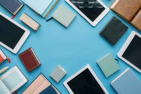 Tablets and e-readers arranged on a blue background, showing the modern shift toward digital learning.の素材