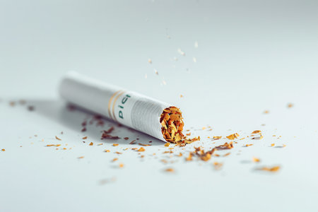 A close-up view of a broken cigarette lying on a white surface, symbolizing the decision to quit smoking and embrace a healthier lifestyle.の素材