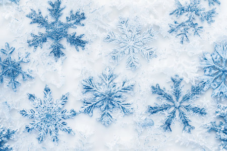 Intricately designed blue snowflakes rest elegantly on a pristine white surface, adding a touch of winter magic and elegance.の素材