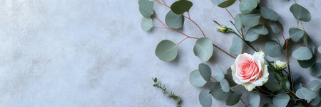 Soft roses paired with fresh eucalyptus leaves create a trendy bouquet set against a minimalist concrete background, enhancing its elegance.の素材