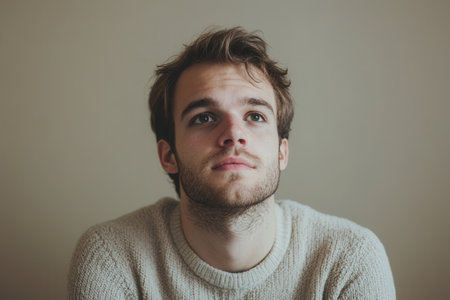 The man appears lost in thought, looking up with a serious expression, suggesting deep contemplation or reflection.の素材