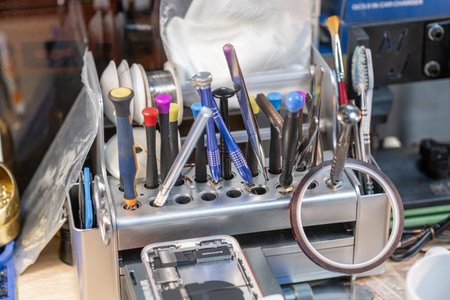 Tools organized neatly at a repair station, ready for phone repairs and battery replacements in a...