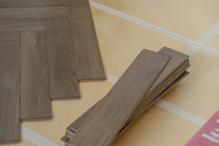 Laminate floor installation in a modern apartment, showing tools, planks, and underlay for a precise and clean floor finishの写真素材