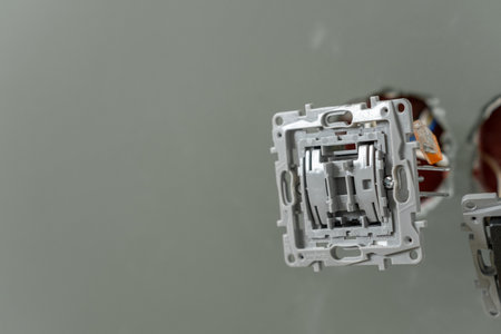 Workers are installing electrical outlets as part of a home renovation project against gray walls.の写真素材