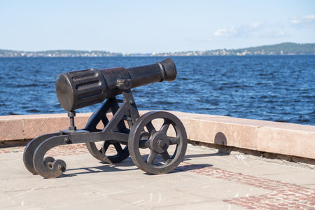 A historical cannon is placed against the scenic backdrop of Lake Onega, highlighting Petrozavodsk's rich history and cultural significance.の写真素材