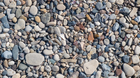 The beach showcases a diverse collection of smooth and colorful pebbles scattered along the shore,...