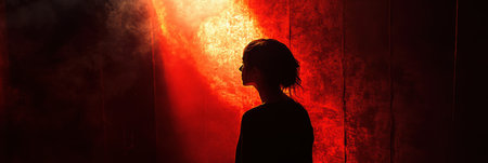 In a dimly lit space, a solitary figure is highlighted by a strong spotlight, evoking feelings of fear and deep suspense.の素材