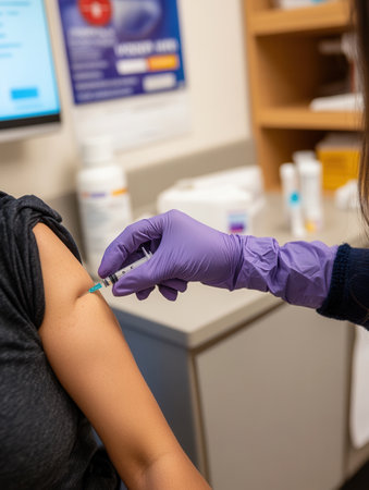 A healthcare worker in gloves gives a vaccine to a patient in a clinical setting, focusing on health and safety.の素材