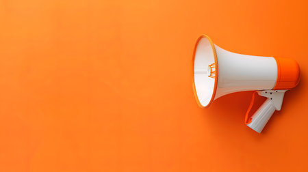 The megaphone stands prominently on a bold orange backdrop, symbolizing communication and engagement during events.の素材