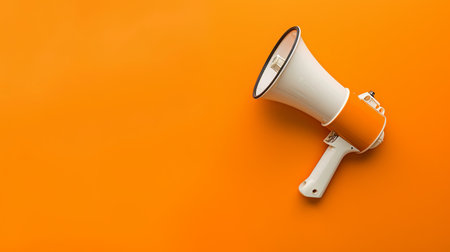 A vibrant orange megaphone is positioned against a solid orange background, creating a striking and cohesive visual effect.の素材