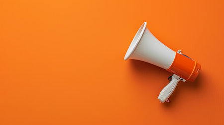 The vibrant megaphone rests against a bright orange surface, symbolizing energy and engagement at community events.の素材