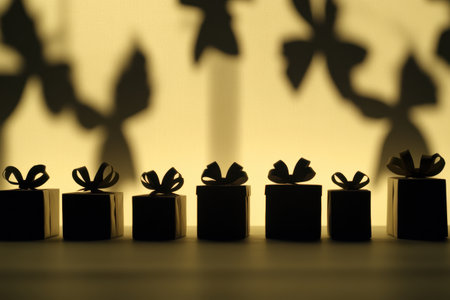 Silhouettes of wrapped gift boxes with decorative bows cast against a soft, light background create a cheerful and festive mood.の素材