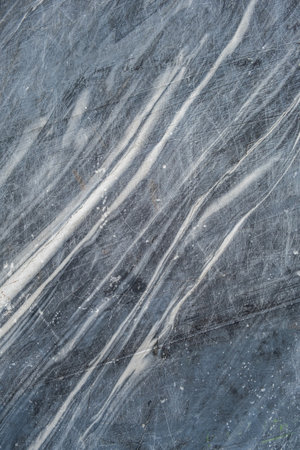 This polished dark marble surface features beautiful white veining patterns, perfect for luxurious interior design applications.の写真素材