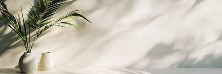 Greenery from potted plants complements the simple decor against a softly lit wall, creating a serene atmosphere in the afternoon.の素材