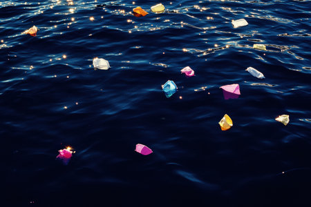 Bright plastic waste is scattered across the surface of a deep blue ocean, showing the pressing issue of environmental pollution.の素材