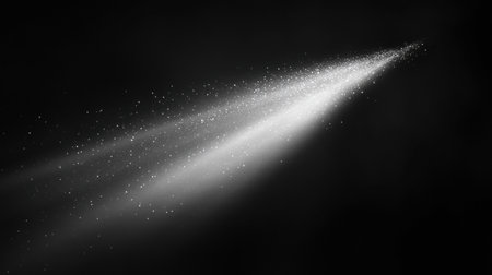 A striking beam of light breaks through an expanse of deep darkness, revealing shimmering particles suspended in the air around it.の素材
