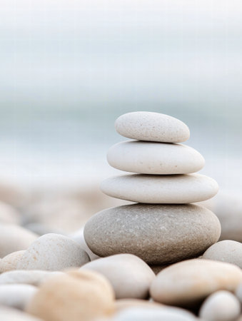 Smooth beach pebbles are piled carefully as waves gently roll over the shoreline, creating a peaceful coastal atmosphere at sunset.の素材
