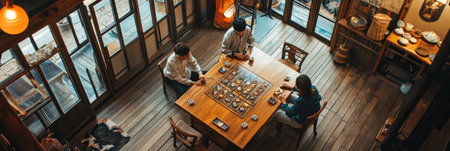 Friends gather around a wooden table playing a board game in a warmly lit room, enjoying each others company in the afternoon.の素材