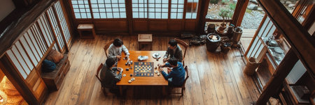 Five adults gather around a wooden table, intensely focused on a board game in a cozy, traditional Japanese setting with natural light.の素材