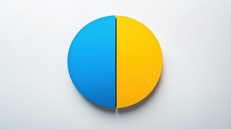 A circular object shows a vibrant division with one half blue and the other half yellow, placed on a clean white surface, conveying creativity.の素材