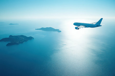 An airplane soars high above a vast blue ocean, revealing small islands dotting the serene water under clear skies.の素材