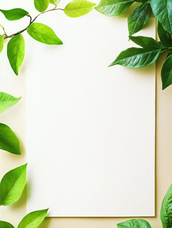 A blank sheet of paper rests on a beige surface, adorned by vibrant green leaves from various plants, creating a fresh atmosphere.の素材