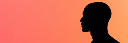 Silhouette of an individual showcasing bald patches, set against a warm gradient background during twilight, emphasizing human features.の素材