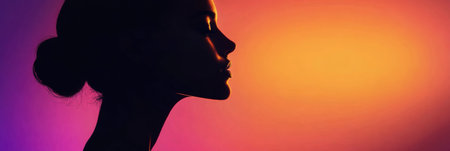 A models silhouette is captured in profile, illuminated by a glowing sunset that creates a beautiful gradient of colors in the background.の素材