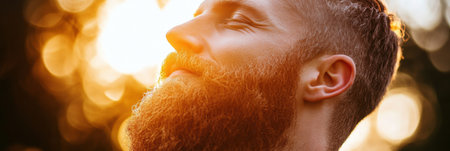 A man with a full beard smiles softly as warm sunlight filters through trees, creating a serene atmosphere during golden hour.の素材
