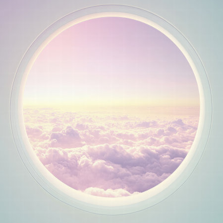 Soft pastel colors blend in the sky as sunlight filters through fluffy clouds outside a round cabin window during sunset.の素材