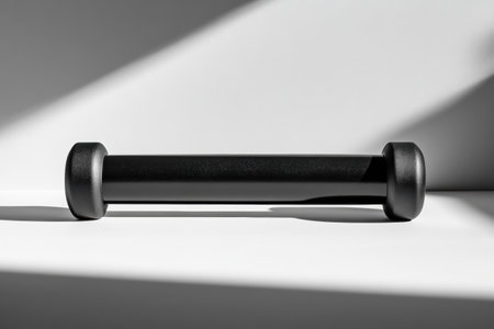 A fitness roller rests on a smooth surface, surrounded by negative space, showing a minimalist design that emphasizes simplicity and form.の素材