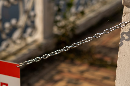 A close-up view of a chain barrier at Peterhof, highlighting the intricate details of the architecture and the surrounding environment in the background.の写真素材