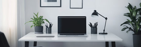 Monochrome home office displays a clean desk with a laptop, organized stationery, soft lighting, and stylish plants, creating an inviting work environment.の素材