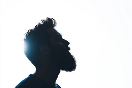 A bearded man is seen in profile, showcasing a striking silhouette with a gentle fade effect on a clean white background, evoking contemplation and tranquility.の素材