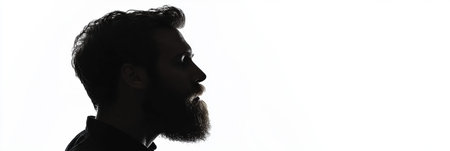 A side profile silhouette of a man with a thick beard is gently fading into a white background, creating a visually striking effect and feeling of simplicity.の素材