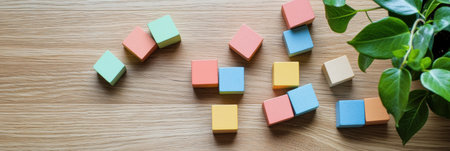 Pastel toy blocks are scattered playfully on a warm natural wood floor, complemented by a nearby green plant, enhancing the minimalist ambiance.の素材
