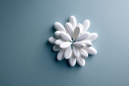 A clean white pill is artistically arranged to form a blooming flower shape on a gentle blue surface, reflecting a sense of wellness and simplicity.の素材