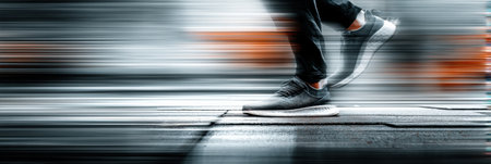 Feet striking the ground while running on a city sidewalk during twilight, captured with a slow shutter technique to create motion blur.の素材