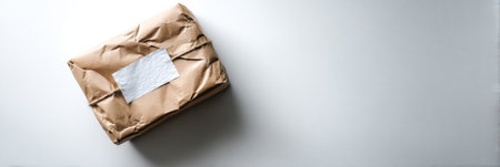 A parcel with a fragile sticker rests on a clean, white surface, showing a minimalist design that emphasizes careful handling and presentation.の素材