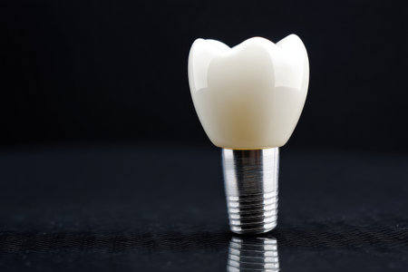 A single white ceramic tooth implant is positioned on a reflective surface, highlighting its smooth finish and contemporary design for dental applications.の素材