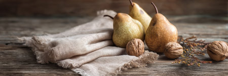A rustic wooden table displays ripe pears, scattered walnuts, and a soft linen napkin, evoking a warm and inviting atmosphere perfect for an autumn feast.の素材